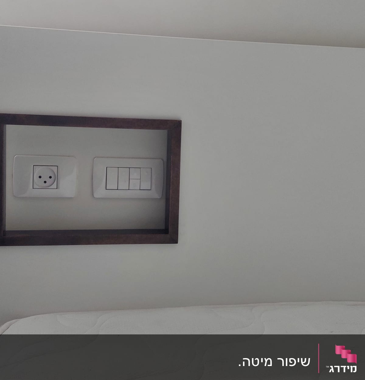 שקע חשמל ומתגים במסגרת עץ על קיר